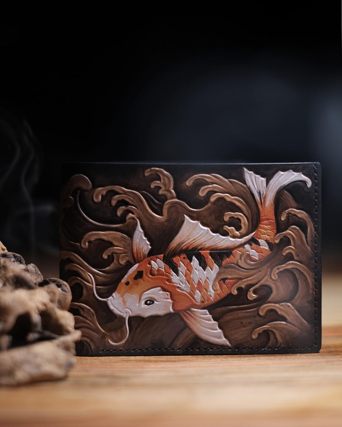 A cat portrait carved onto a black leather wallet